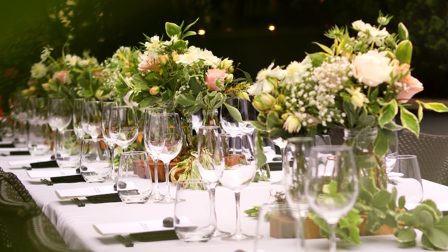 Eine gedeckte Tafel mit Geschirr für eine Gartenhochzeit