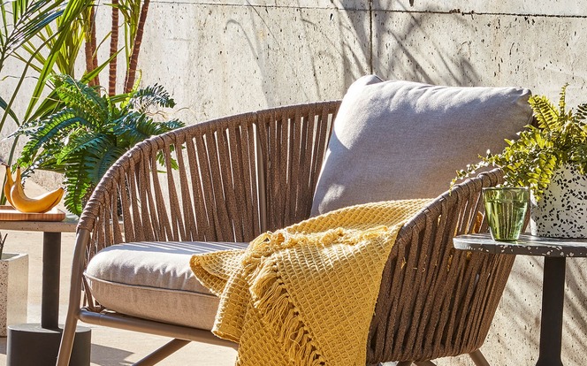 Gelbe Outdoordecke auf einem Loungestuhl auf der Terrasse