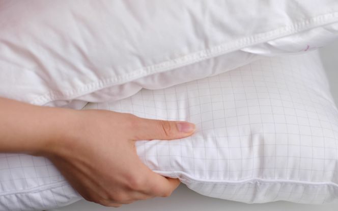 young-woman-touching-soft-white-pillow-closeup